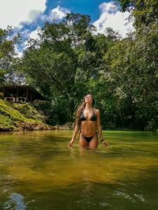 Una mujer en bikini parada en un río en Paraíso Escondido Cabañas, Reserva Rio Claro, San Luis-Doradal, en San Luis