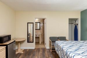 um quarto de hotel com uma cama, uma mesa e cadeiras em Stay Express Inn Elko em Elko