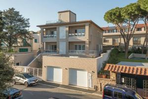 un immeuble d'appartements avec une voiture garée sur un parking dans l'établissement Prima dell'Elba Family Apartments, à Piombino