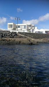 una masa de agua con edificios en el fondo en Villa Sama en Punta de Mujeres