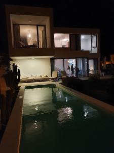 a swimming pool in front of a house at night at Villa Sama in Punta Mujeres