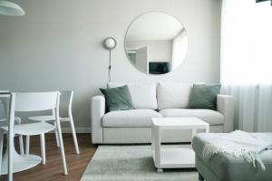 a living room with a couch and a mirror at Grey Green Cozy Apartment in Birštonas
