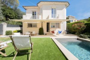 eine Villa mit einem Pool und einem Haus in der Unterkunft House with heated swimming pool in Cannes