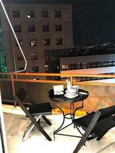 ein Tisch und Stühle auf einem Balkon in der Nacht in der Unterkunft Cozy Modern Studiο _ Near the Center of Athens in Athen