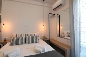 ein Schlafzimmer mit einem Bett mit zwei Kissen und einem Spiegel in der Unterkunft Cozy Modern Studiο _ Near the Center of Athens in Athen