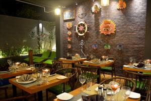 um restaurante com mesas e cadeiras de madeira e uma parede de tijolos em Belmont Boutique Hotel em Negombo