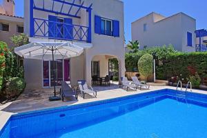 a house with a swimming pool with chairs and an umbrella at Villa Irina Polis in Polis Chrysochous