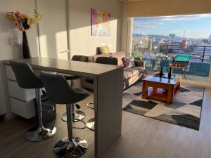 uma sala de estar com uma mesa e um sofá em Departamento Amoblado con excelente ubicación em Concepción