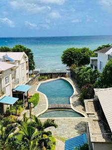 een luchtzicht op een zwembad naast de oceaan bij Hibiscus Penthouse vue mer 2 chambres in Trou aux Biches