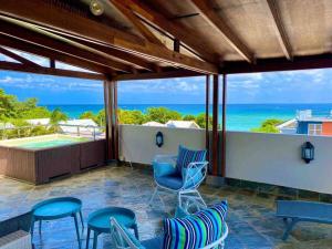 un patio con sillas y vistas al océano en Hibiscus Penthouse vue mer 2 chambres, en Trou aux Biches