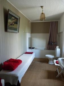 a bedroom with a bed and a tub and a toilet at Le Clos Notre Dame B&B in Mareuil