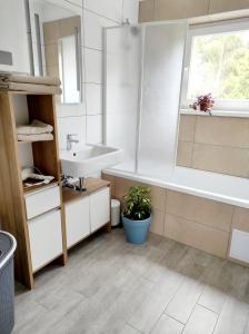 a bathroom with a sink and a bath tub and a sink at Sigi Apartment in Barnbach