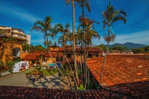 a view of a house with palm trees and a roof at Giprita Wellness Hotel Ubatuba in Ubatuba