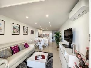 sala de estar con sofá y TV en VILLA MAUPASSANT T2 BORD DE MER en Cannes
