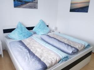 een bed in een kamer met blauwe kussens bij Strandzauber in Breege