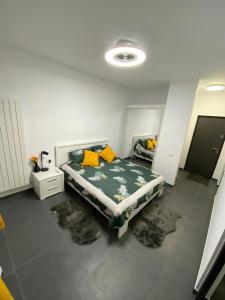 - une chambre avec un lit doté d'oreillers jaunes dans l'établissement Garsoniera Adi, à Eforie Nord