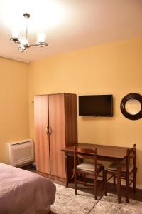 a bedroom with a desk and a flat screen tv at Vila Visi Hotel in Korçë
