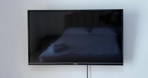 a flat screen tv sitting on a wall at Hotel NINO in Dhërmi