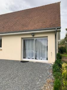a detached house with a large window at Le Mesnil Normand in Fort-Moville