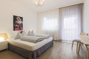 - une chambre blanche avec un lit et un lustre dans l'établissement Albergo Gasthof Salurn, à Salorno