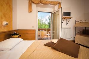 a bedroom with a bed and a sliding glass door at Albergo Ristorante il Fungo in Santa Fiora
