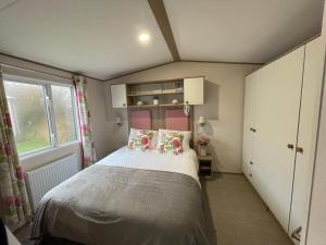 Tempat tidur dalam kamar di Forget Me Not Caravan - Littlesea Haven Holiday Park, Weymouth