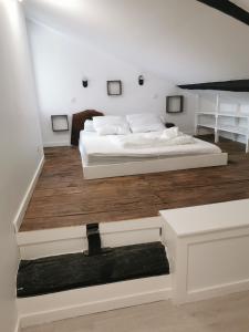 Habitación blanca con cama y suelo de madera. en EMBATA, en Ustaritz