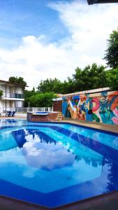 a swimming pool with a mural on the side of a building at Villa Alejandra in Girardot
