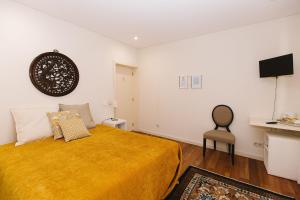 a bedroom with a bed and a chair in it at Casa do Passadiço - Alvarenga in Alvarenga