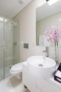 a white bathroom with a sink and a toilet at Casa do Passadiço - Alvarenga in Alvarenga