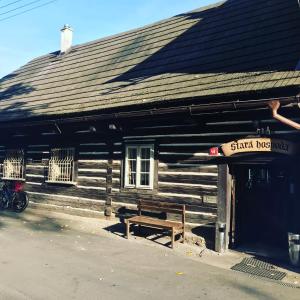 a wooden building with a bench in front of it at Pension Stará hospoda in Dobřív