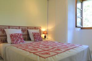 um quarto com uma cama com uma colcha vermelha e branca em Gîte 829 Montagnes du Jura avec Spa et Sauna classé 3 étoiles em Foncine-le-Haut