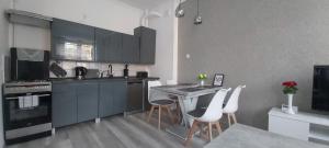 a kitchen with black cabinets and white chairs and a table at apartament u Eli in Stronie Śląskie