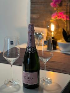 a bottle of wine next to two glasses on a table at Apartment threeRivers in Passau