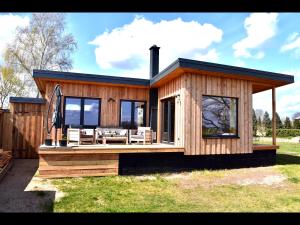 a small wooden house with a deck and chairs at Ferienhaus M&M in Schwarz