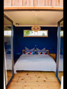 1 dormitorio con 1 cama grande y paredes azules en Ferienhaus M&M, en Schwarz