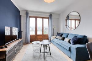 uma sala de estar com um sofá azul e uma televisão em Superbe Appartement de standing au cœur de Lille em Lille