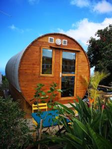 une maison en bois circulaire avec une fenêtre et un banc dans l'établissement Le Myranoa, bungalow/tonneau, à Saint-Pierre