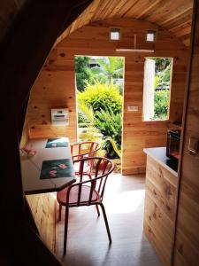 ein Zimmer mit einem Tisch und Stühlen in einer Hütte in der Unterkunft Le Myranoa, bungalow/tonneau in Saint-Pierre