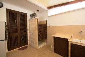 y baño con puertas marrones, lavabo y ducha. en VILLA ANNA, en Torre Pali