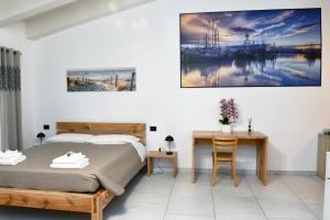 Dormitorio con cama, escritorio y pintura en La Pineta del Borgo en Rávena