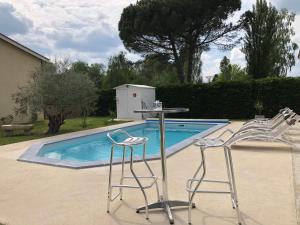 twee stoelen en een tafel naast een zwembad bij Ô Sauternes in Sauternes