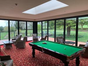 a pool table in a room with windows at Thornton Lodge in Aysgarth