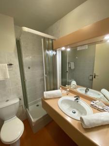 a bathroom with a sink and a toilet and a shower at Hôtel du Parc in Le Mont-Dore
