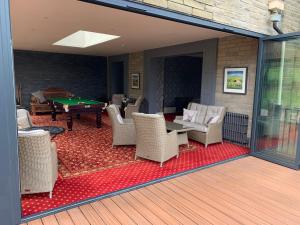 a screened in patio with a pool table and chairs at Thornton Lodge in Aysgarth