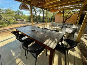 a wooden table and chairs on a patio at Rixile Kruger Lodge in Skukuza