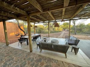 a pavilion with a table and chairs on a patio at Rixile Kruger Lodge in Skukuza