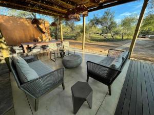 a patio with chairs and a table with a view of the wilderness at Rixile Kruger Lodge in Skukuza