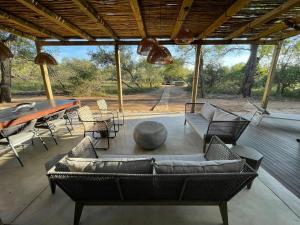 a patio with couches and a table and chairs at Rixile Kruger Lodge in Skukuza