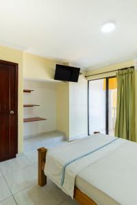 sypialnia z dużym łóżkiem i oknem w obiekcie Hotel Costa mar w mieście Barranquilla